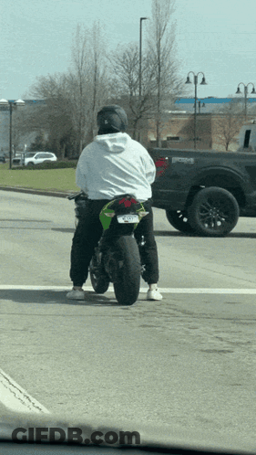 A Man Riding A Green Motorcycle With A License Plate That Says ' Jcl ' On It GIF