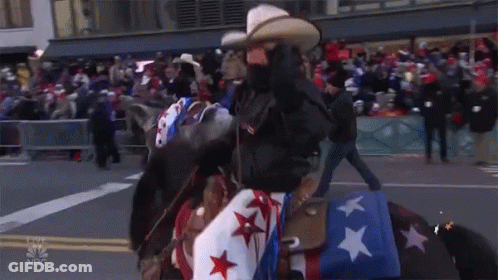 A Man Riding A Horse In A Parade With A Merry Thanksgiving Star GIF