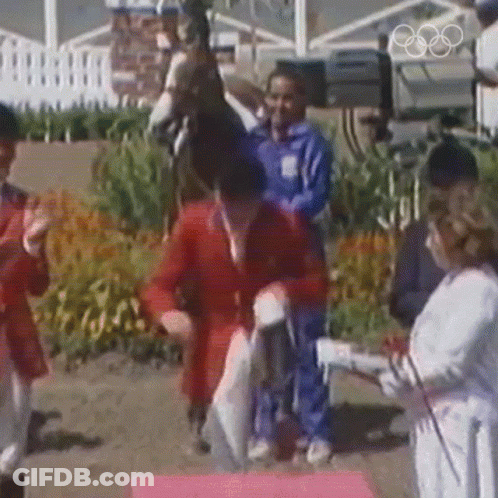 A Man Riding A Horse Is Being Congratulated By A Woman GIF