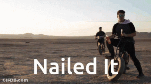 A Man Riding A Motorcycle In The Desert With The Words Nailed It Above Him GIF
