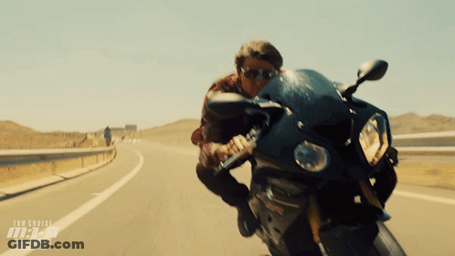 A Man Riding A Motorcycle On A Highway With The Word Tom Cruise On The Bottom Right GIF