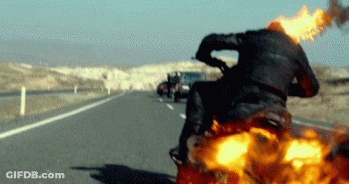 A Man Riding A Motorcycle With Flames Coming Out Of The Back GIF