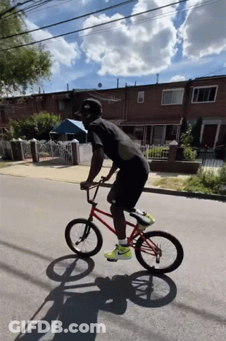 A Man Riding A Red Bmx Bike On A Street GIF