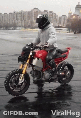 A Man Riding A Red Ducati Motorcycle In The Rain GIF