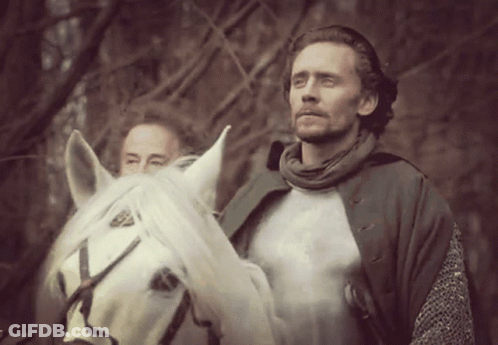 A Man Riding A White Horse With Another Man Standing Behind Him GIF