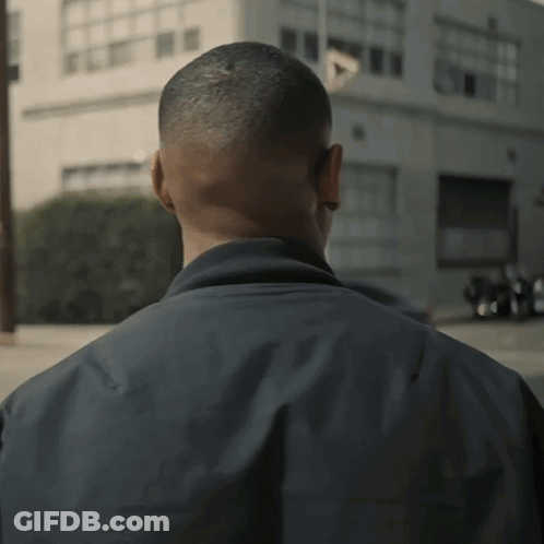 A Man 'S Back Is Shown In A Blurry Photo With A Building In The Background GIF