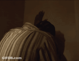 A Man 'S Back Is Shown In A Dark Room GIF