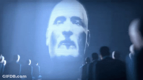 A Man 'S Face Is Projected On A Large Screen GIF
