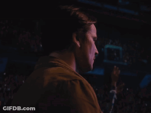 A Man 'S Face Is Shown In A Dark Room GIF