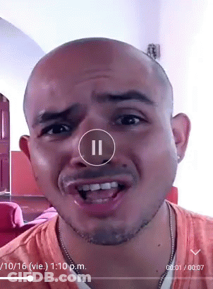 A Man 'S Face Is Shown In A Video With A Pause Button In The Corner GIF