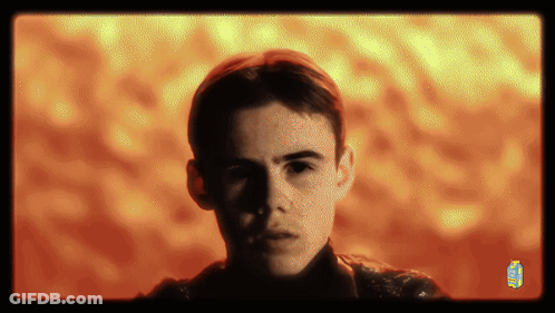 A Man 'S Face Is Shown In Front Of A Yellow And Orange Background With A Juice Box In The Corner GIF