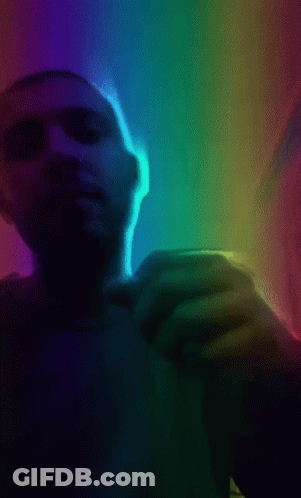 A Man 'S Hand Is Reaching Out Towards A Rainbow Light GIF