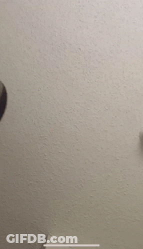 A Man 'S Head Is Against A White Wall GIF