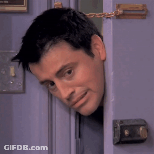 A Man 'S Head Is Sticking Out Of A Door With A Chain Around It GIF