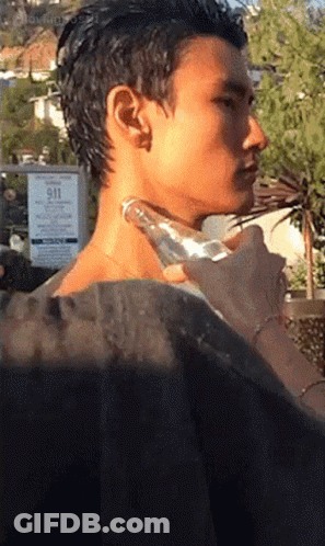 A Man 'S Neck Is Being Massaged In Front Of A Sign That Says 911 On It GIF