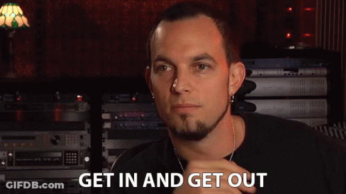 A Man Says Get In And Get Out In Front Of A Stack Of Electronics GIF