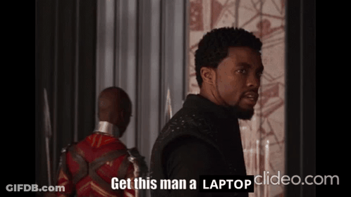 A Man Says Get This Man A Laptop In Front Of Another Man GIF