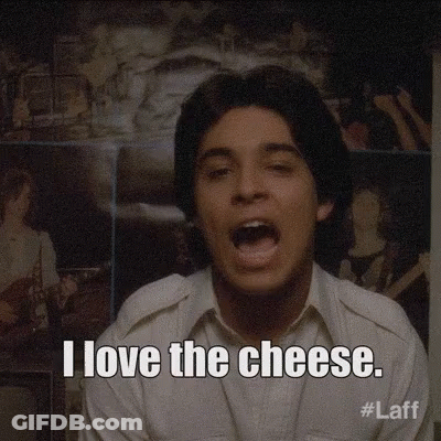 A Man Says I Love The Cheese In Front Of A Wall Of Pictures GIF