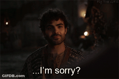 A Man Says I 'M Sorry In Front Of A Dark Background GIF