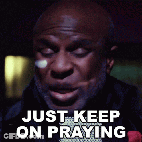 A Man Says " Just Keep On Praying " In Front Of A Dark Background GIF