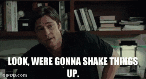 A Man Says Look Were Gonna Shake Things Up In Front Of A Bookshelf GIF