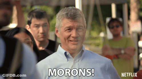 A Man Says Morons While Standing In A Crowd GIF