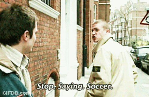 A Man Says Stop Saying Soccer In Front Of A Brick Building GIF