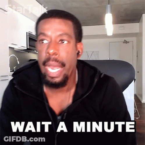 A Man Says Wait A Minute In Front Of A Kitchen GIF