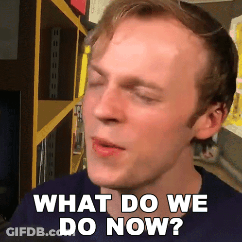 A Man Says What Do We Do Now In Front Of A Shelf GIF