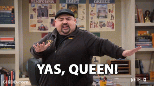 A Man Says Yas Queen In Front Of A Shelf Full Of Books GIF