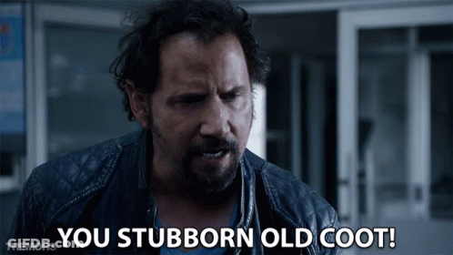 A Man Says You Stubborn Old Coot In Front Of A Door GIF