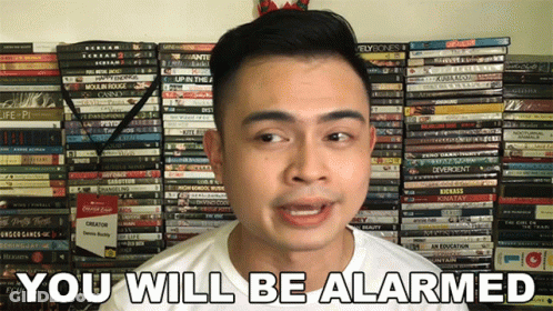 Man Saying You Will Be Alarmed In Front Of DVDs GIF