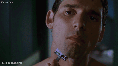 A Man Shaves His Neck With A Razor With Illusive Soul Written In The Upper Right Corner GIF