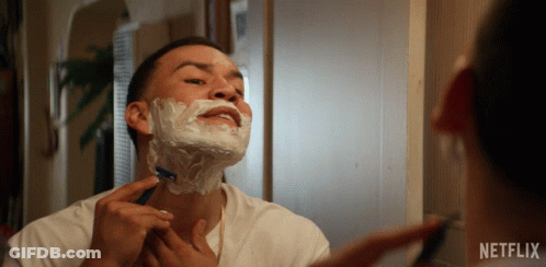A Man Shaving In Front Of A Mirror With A Netflix Logo GIF