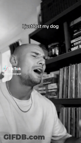 A Man Singing In Front Of A Bookshelf That Says I Just Lost My Dog On It GIF
