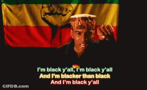 A Man Singing In Front Of A Flag With The Words I 'M Black Y All GIF