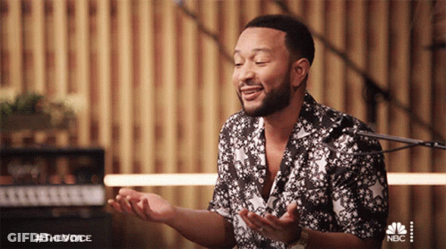A Man Singing In Front Of A Microphone With The Hashtag #Thevoice On The Bottom Right GIF