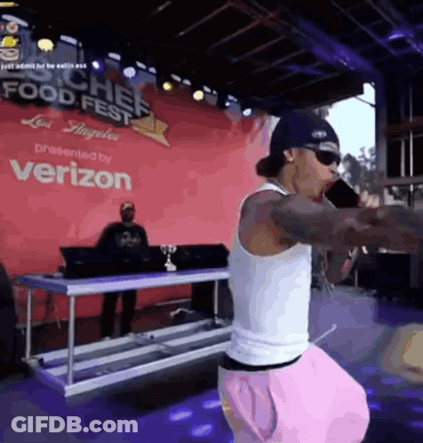 A Man Singing Into A Microphone At A Food Fest GIF