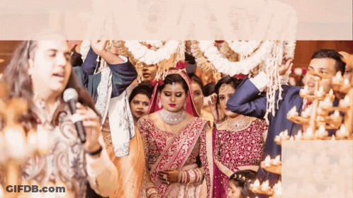 A Man Singing Into A Microphone In Front Of A Bride GIF