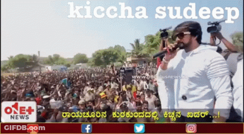 A Man Singing Into A Microphone In Front Of A Crowd With The Words Kiccha Sudeep On The Bottom GIF