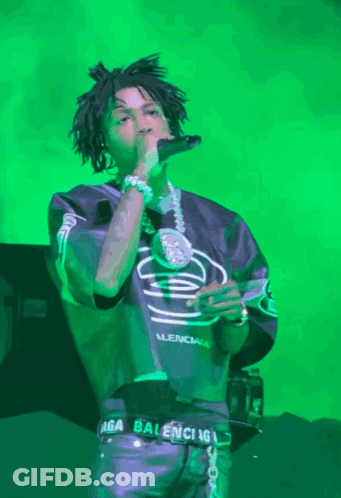 A Man Singing Into A Microphone Wearing A Balenciaga Belt GIF