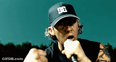A Man Singing Into A Microphone Wearing A Hat With The Letter D On It GIF