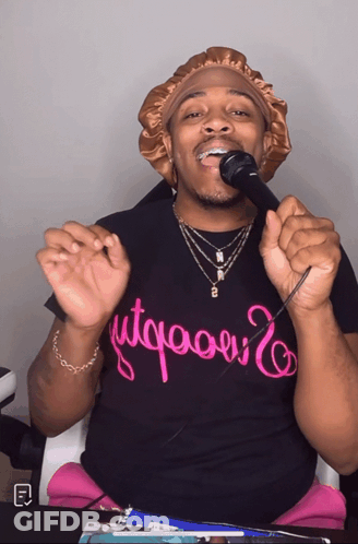 A Man Singing Into A Microphone Wearing A T-Shirt That Says " Utqaoui " GIF
