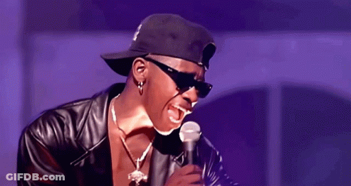 A Man Singing Into A Microphone Wearing Sunglasses And A Hat GIF