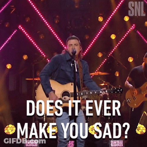 A Man Singing Into A Microphone While Holding A Guitar With The Words " Does It Ever Make You Sad " Above Him GIF