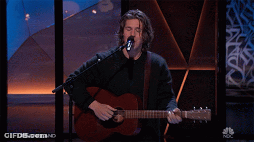 A Man Singing Into A Microphone While Playing A Guitar With The Words Songland On The Bottom Right GIF