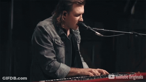 A Man Singing Into A Microphone While Playing A Keyboard With Youtube Originals On The Bottom GIF