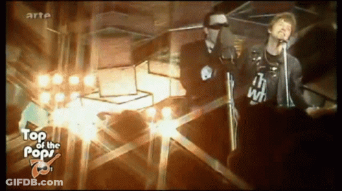 A Man Singing Into A Microphone While Wearing A Shirt That Says " I 'M With " GIF