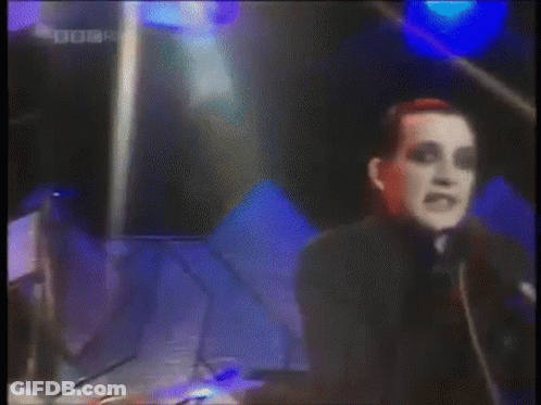 A Man Singing Into A Microphone With A Bbc Four Logo In The Corner . GIF
