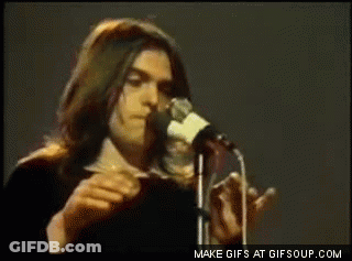 A Man Singing Into A Microphone With Make Gifs At Gifsoup.com At The Bottom Of The Screen GIF